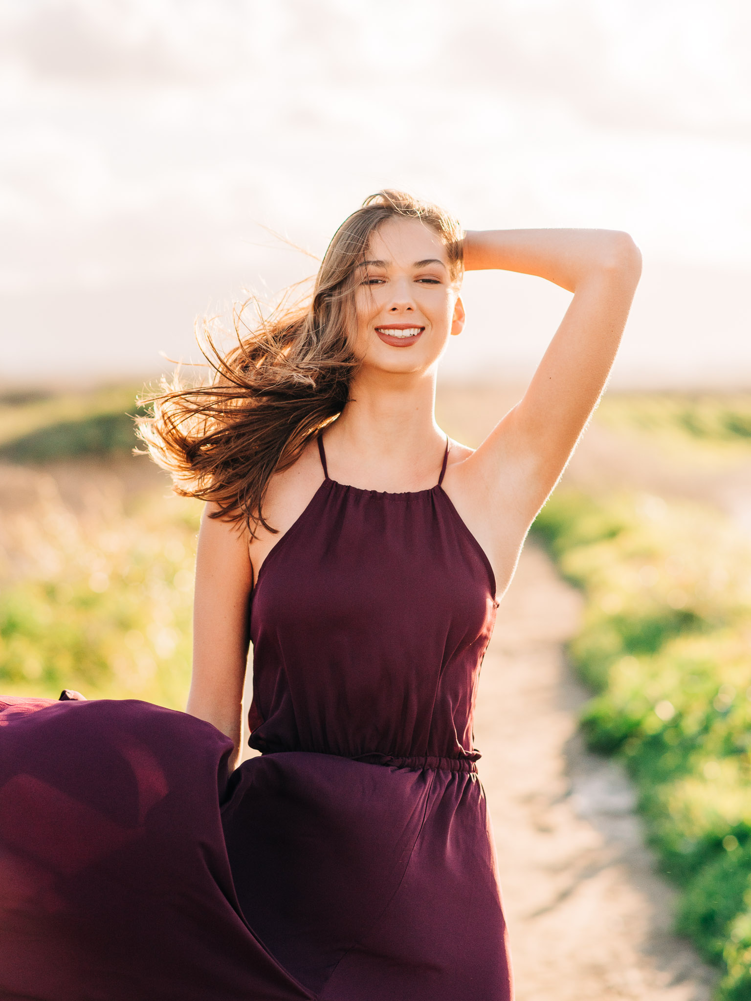 Teen with long dress and hair blowing in the wind, by Emily Kim Photography.