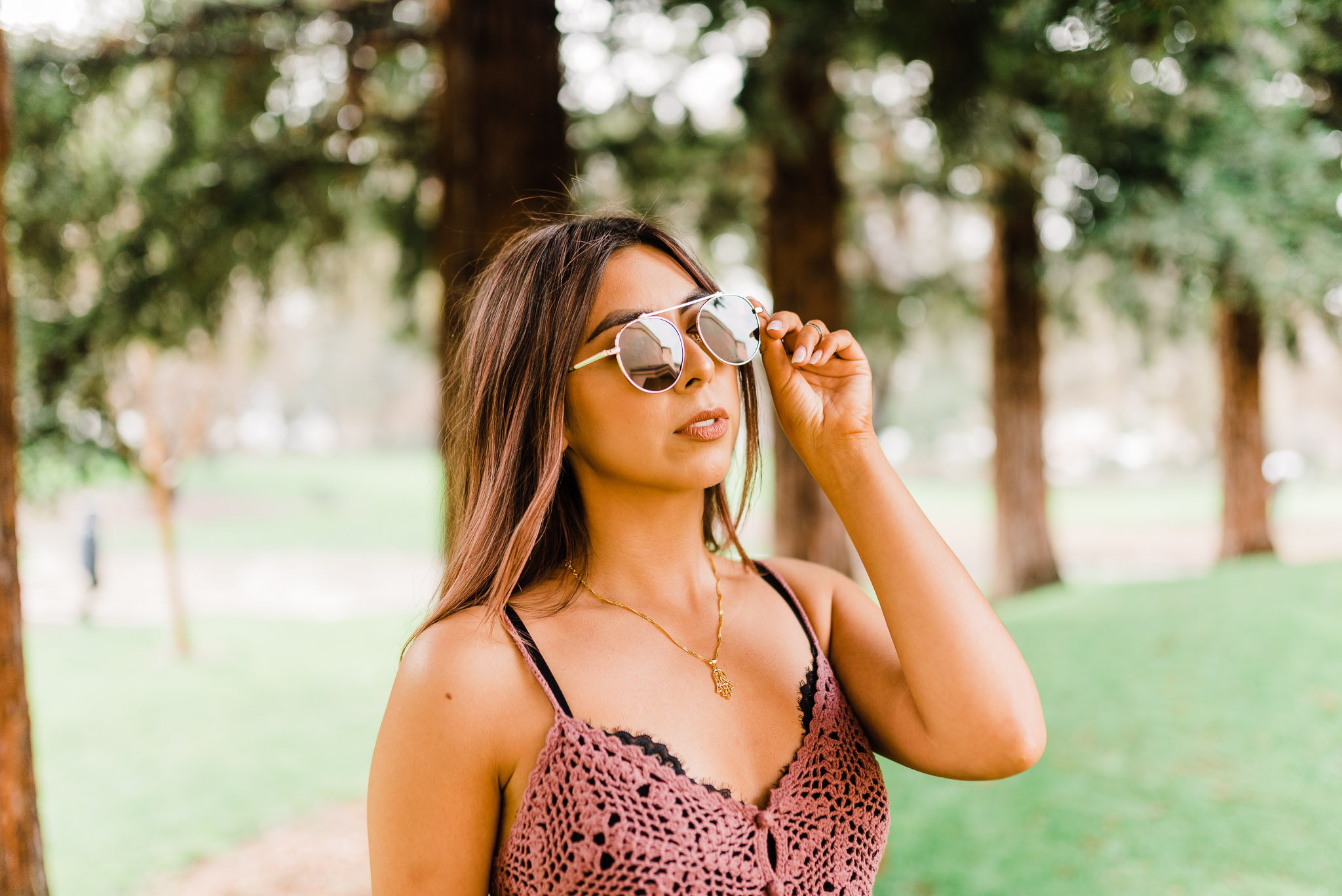 Fashion blogger wearing a mauve crochet top and sunglasses.
