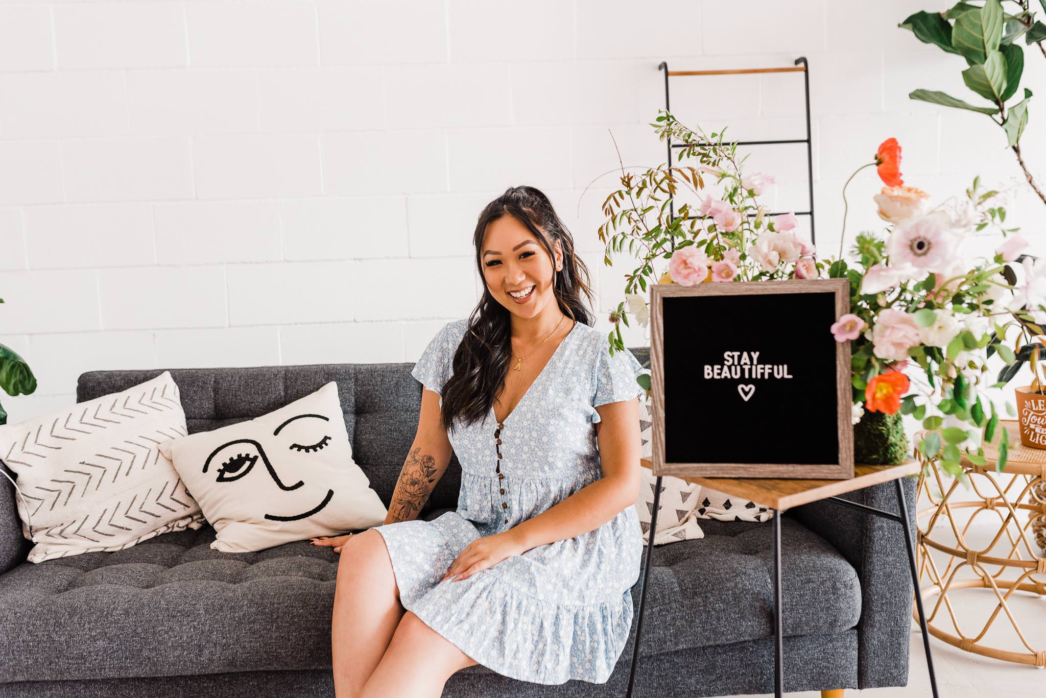 Blogger Tiffany of Stay Beautifful sitting on a couch.