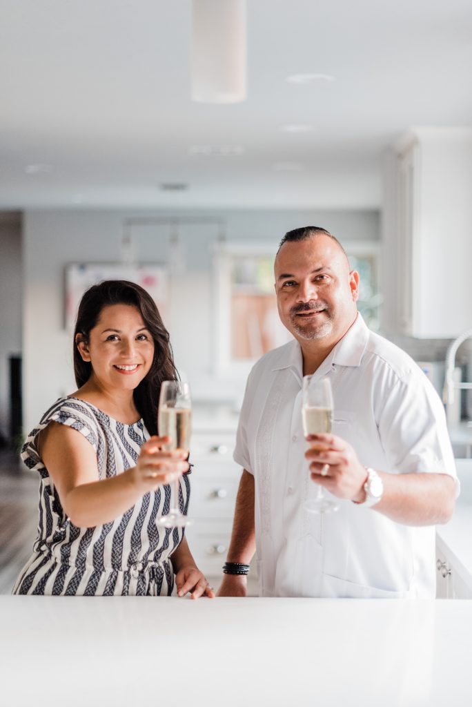husband and wife drinking champagne in the kitchen