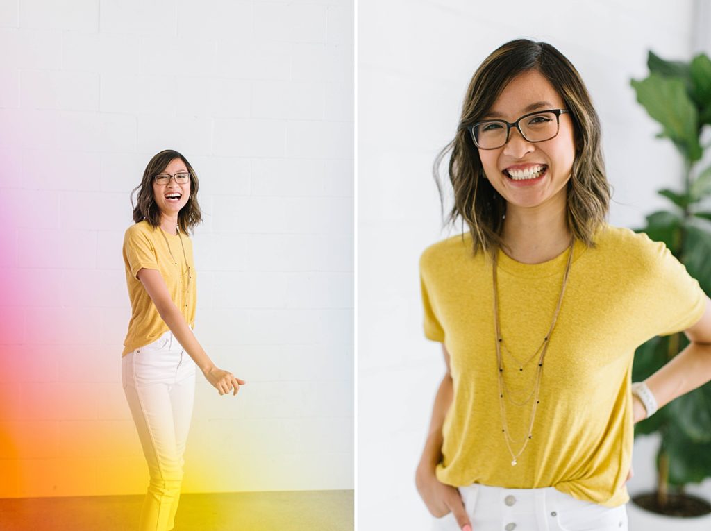 A woman wearing a yellow shirt, white denim, and a long necklace.