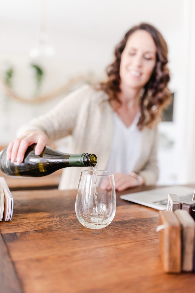 woman pouring wine at the kitchen counter.