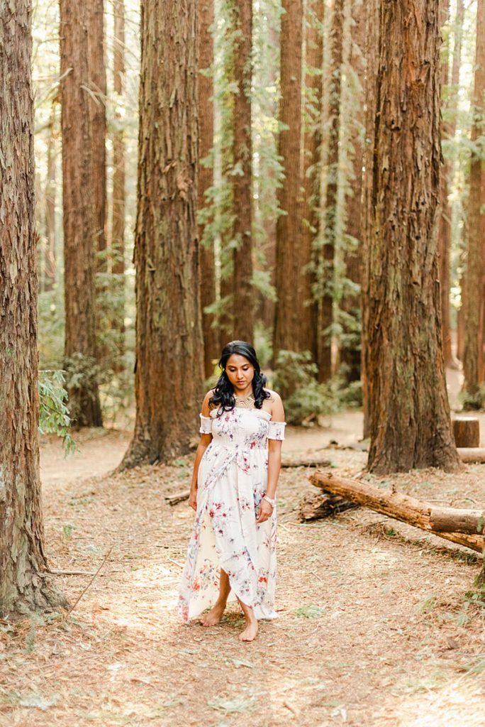 woman in a dress is standing in a forest
