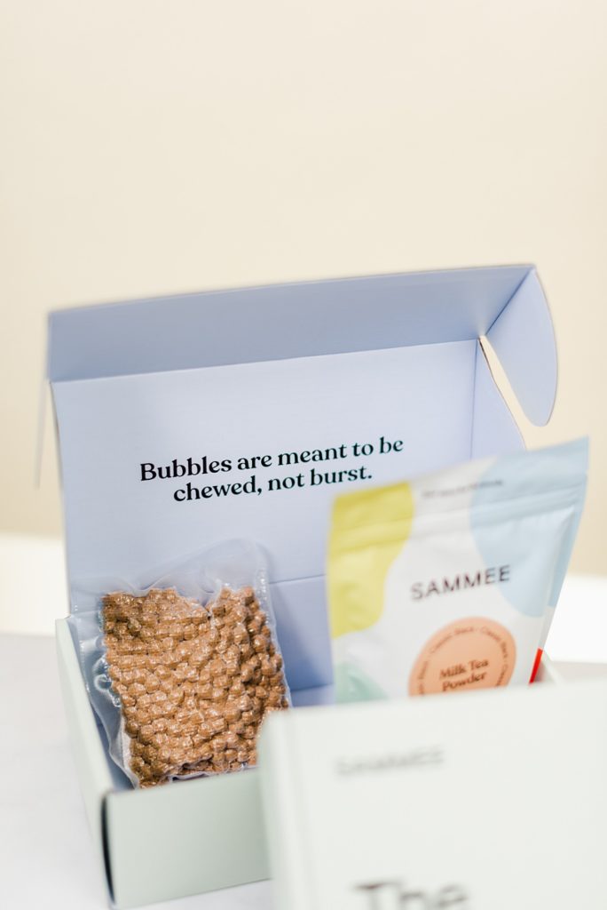 Open box of SAMMEE boba and milk tea powder. "Bubbles are meant to be chewed, not burst" is written on the inner side of the flap.