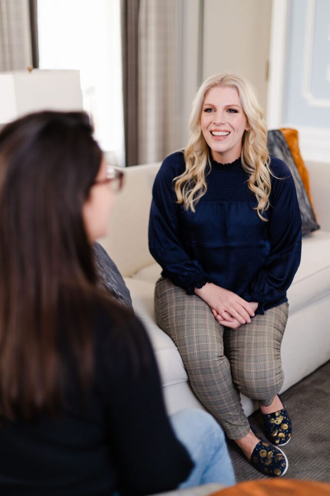 brand photo of woman talking to client sitting on couch