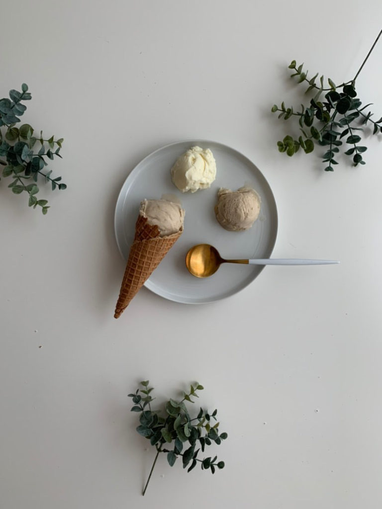 3 scoops of gelato on a plate. one is in a cone.