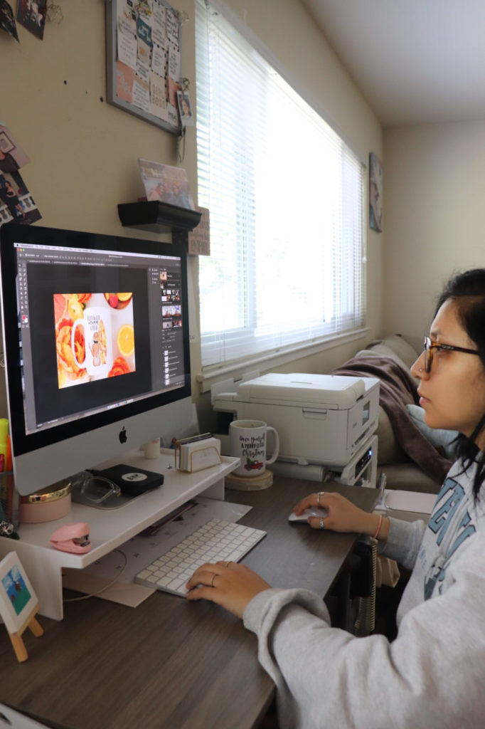 photo of a woman sitting at her computer, working on a design.