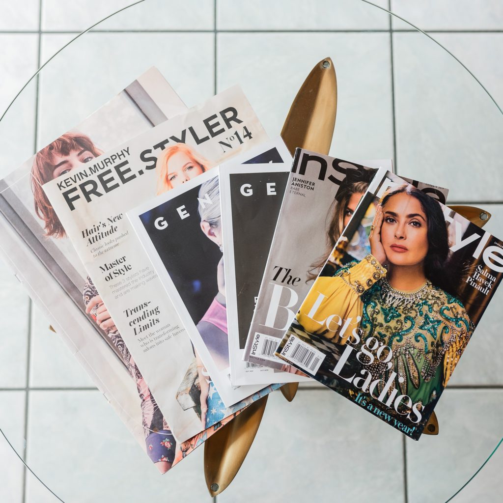 Magazines on a glass table.