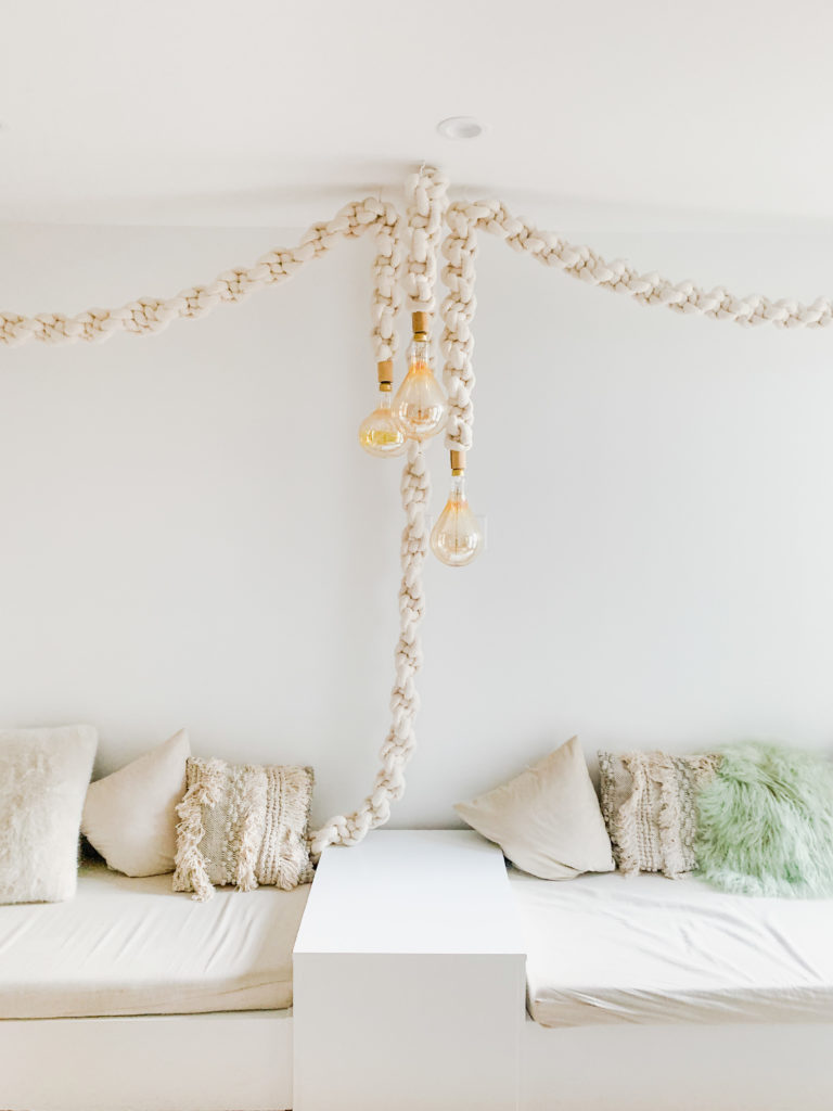 a couch with macrame lights hanging in the middle.