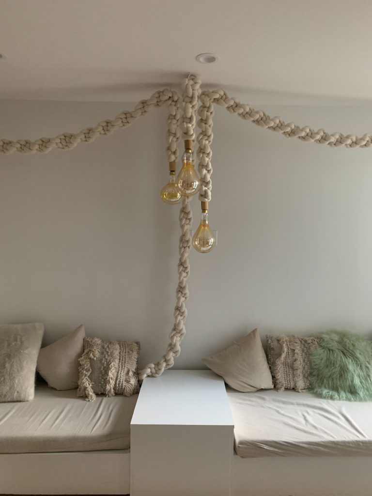 a couch with macrame lights hanging in the middle.