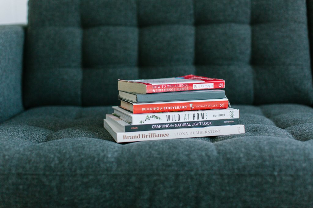 Stack of books on a couch.