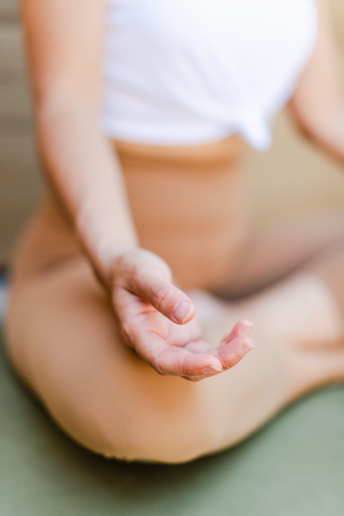 hand resting on a knee in a cross legged position
