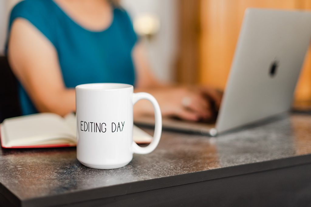 white mug with the words "editing day" written in all caps and a slim handwriting font