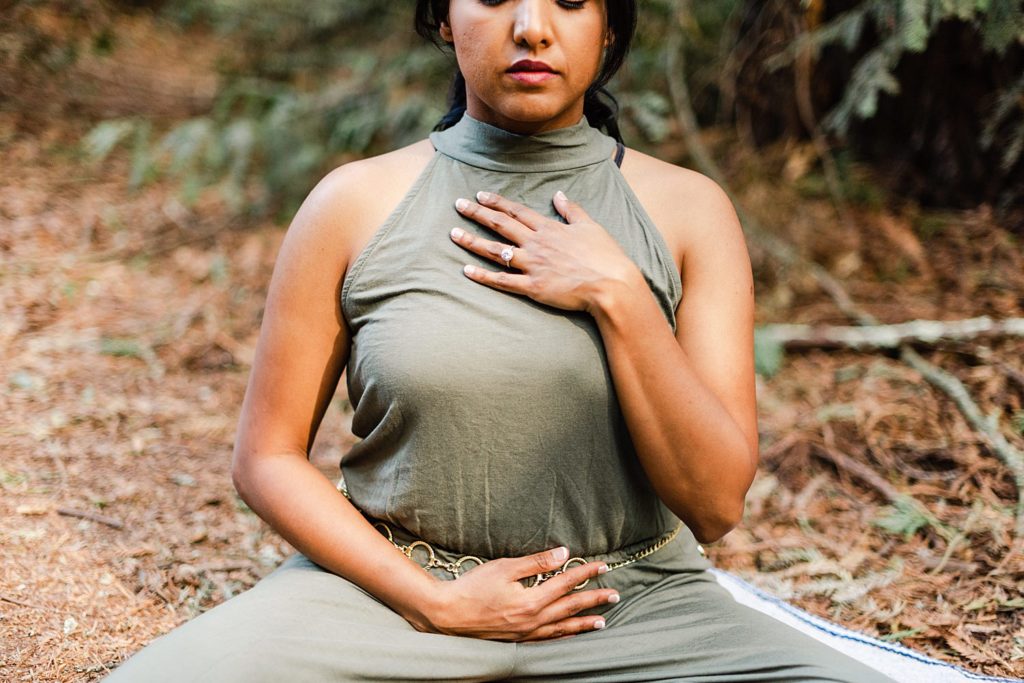 meditating woman with one hand on her chest and the other on her stomach