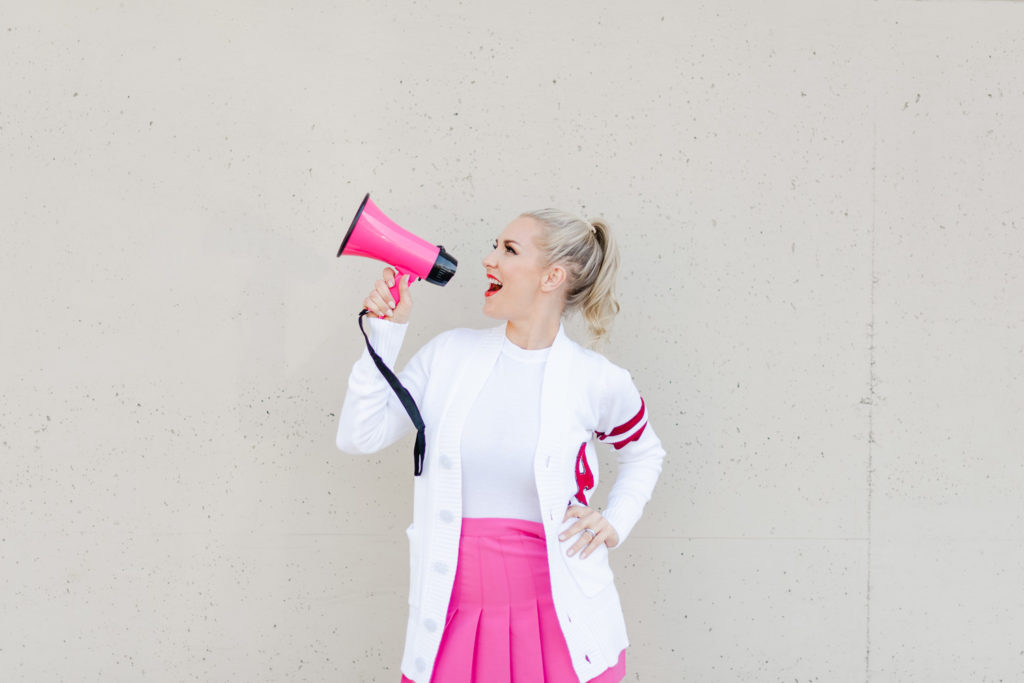 woman speaking into a pink megaphone