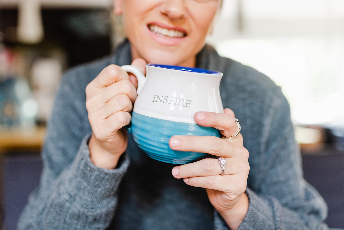 woman holding a big mug with the word 'INSPIRE' on it