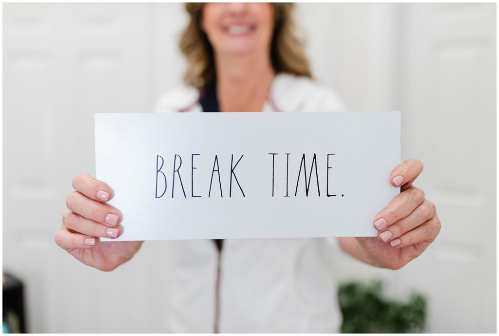 woman holding a card that says "break time"