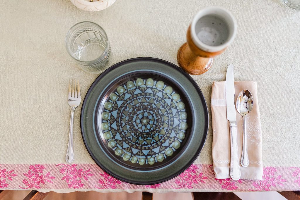 flat lay of a table setting with a bold patterned plate and a ceramic wine glass
