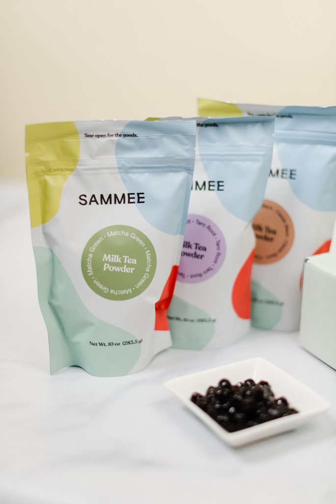 3 SAMMEE Milk Tea Powder packs with a small saucer of boba
