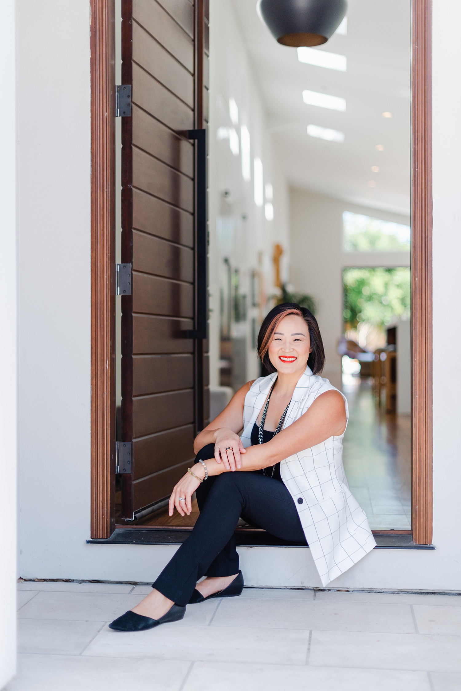 woman in a white vest is sitting in the doorway