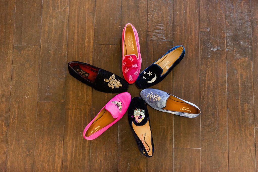 six flat shoes in different colors arranged in a circle with all the toes pointing to the center.