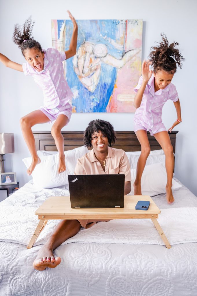 A mom with two kids jumping on the bed