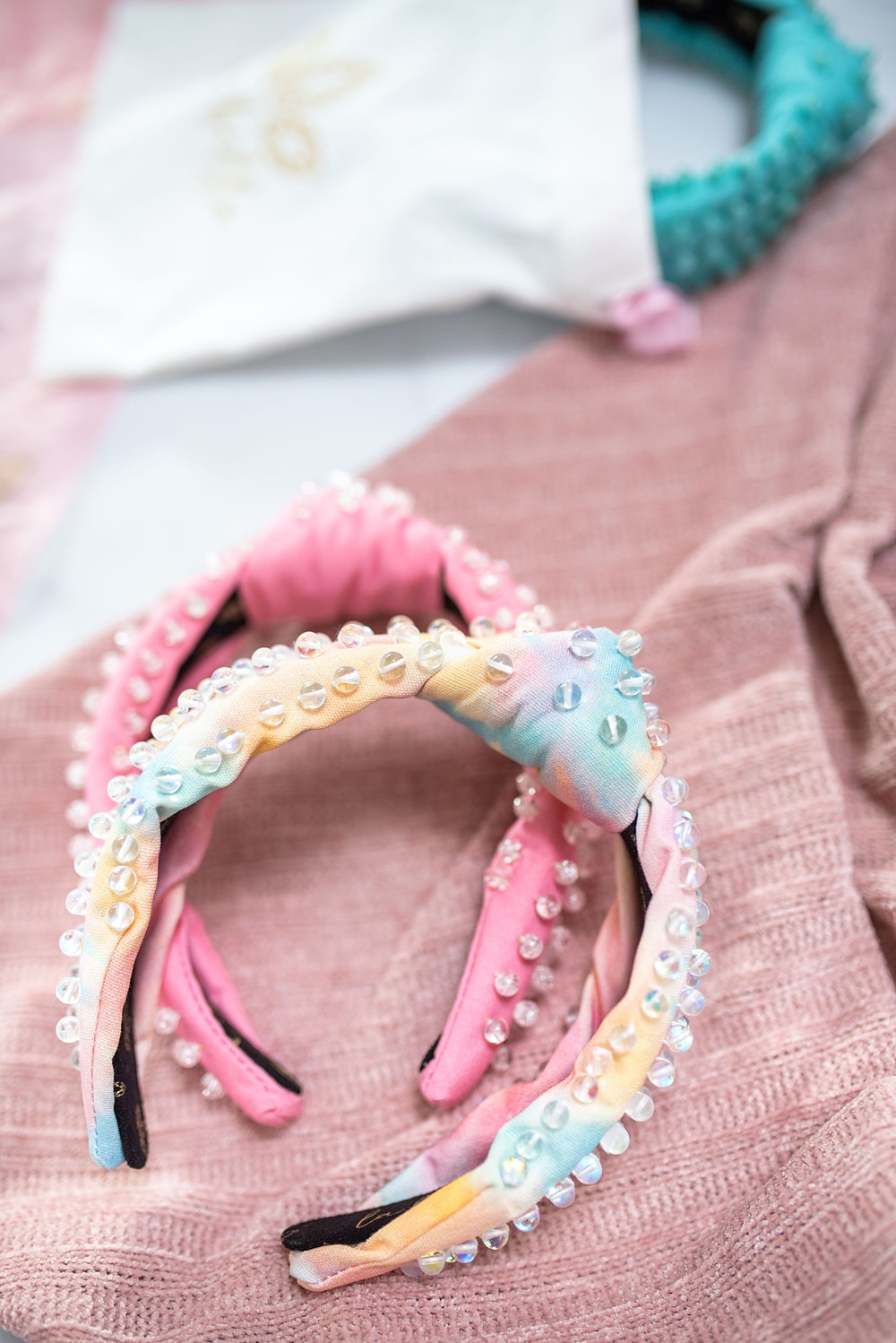 Two pretty pink headbands with small silver decors. There's a blue headband behind.