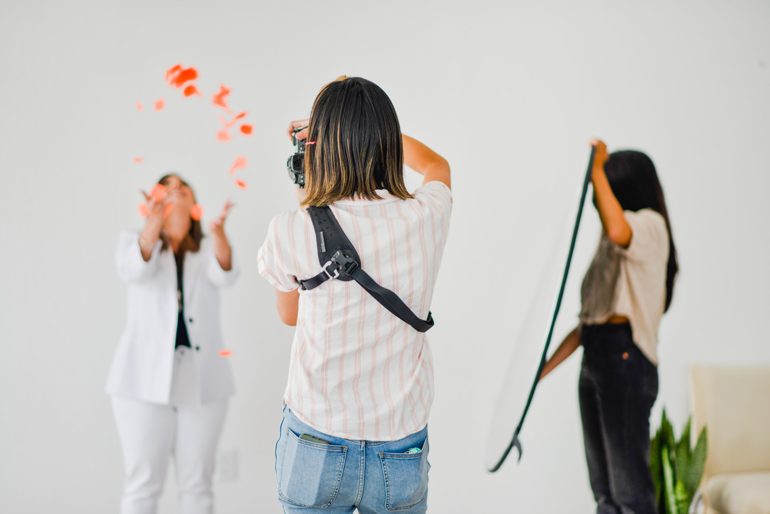 Three Women doing photoshoot. The woman on the left is the model  in the middle is the photographer , and at the right is the props assistant