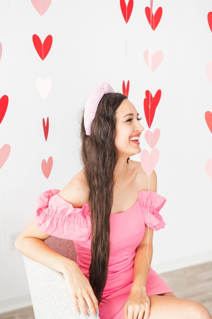 ballerina tweed headband on a model. the model is in a bubblegum pink dress and there are hearts hanging from the ceiling