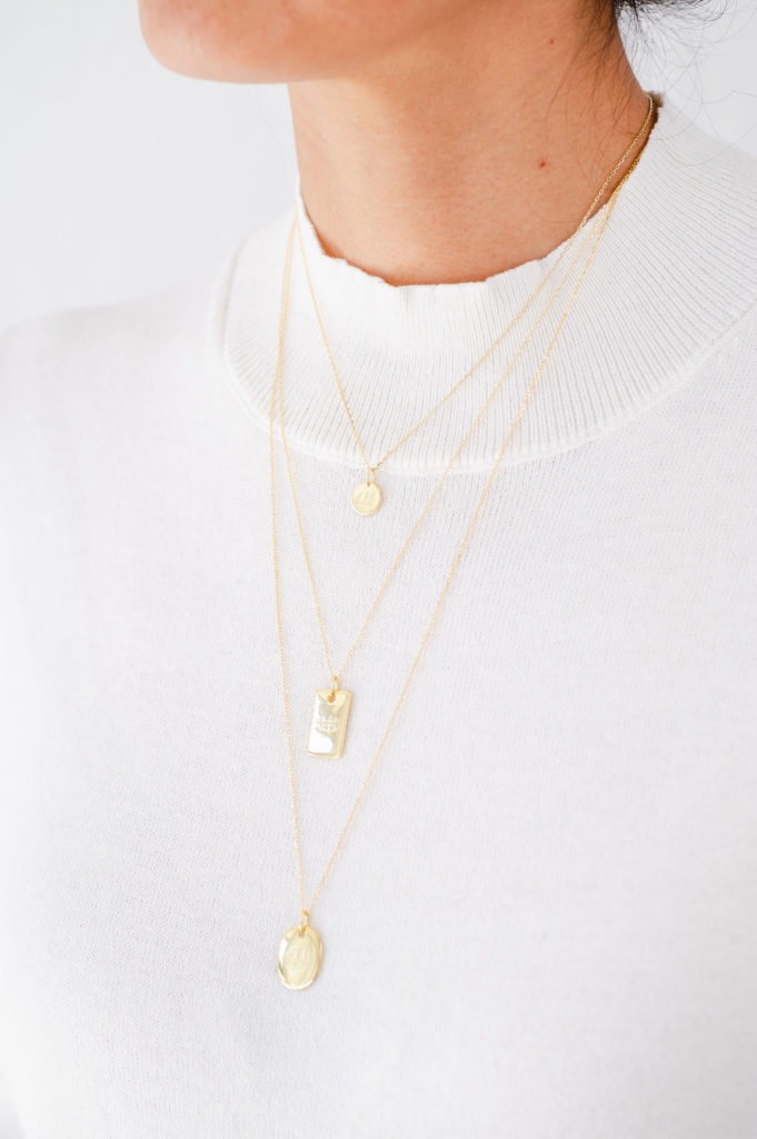woman wearing 3 gold layered Bahai necklaces