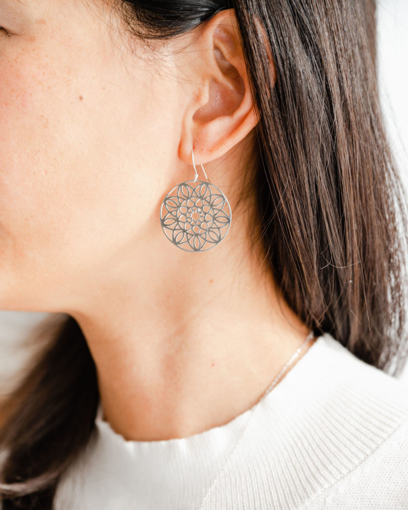 woman wearing a mandala earring.