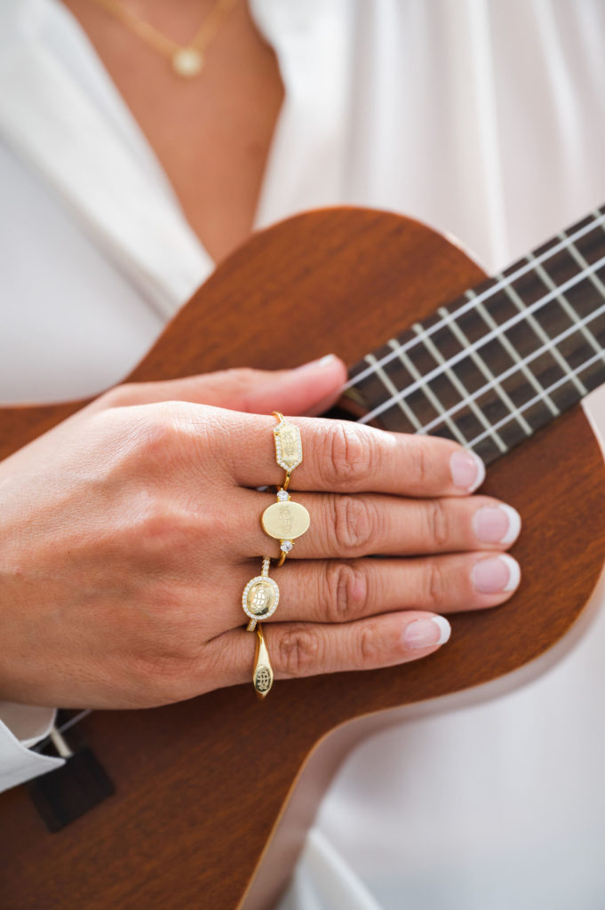 woman holding a ukelele wearing 4 bahai rings