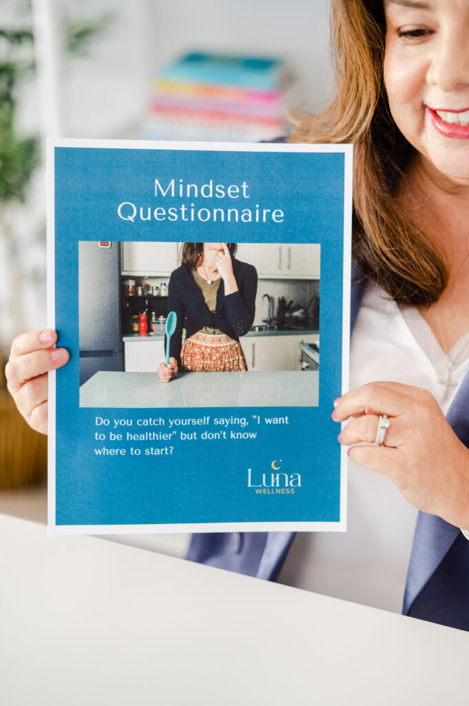 Lisa Lee from Luna Wellness holding a Mindset Questionnaire worksheet