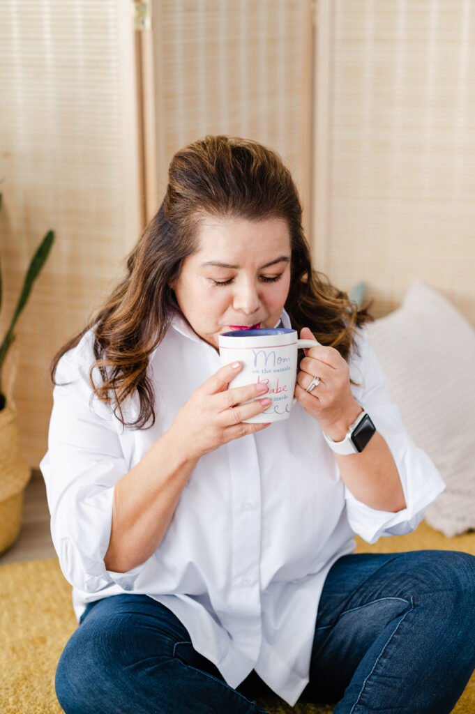 Portrait of woman sitting on floor sipping from a mug
