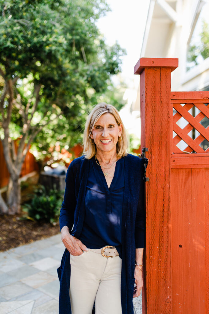 Branding photo of realtor leaning on a fence and smiling