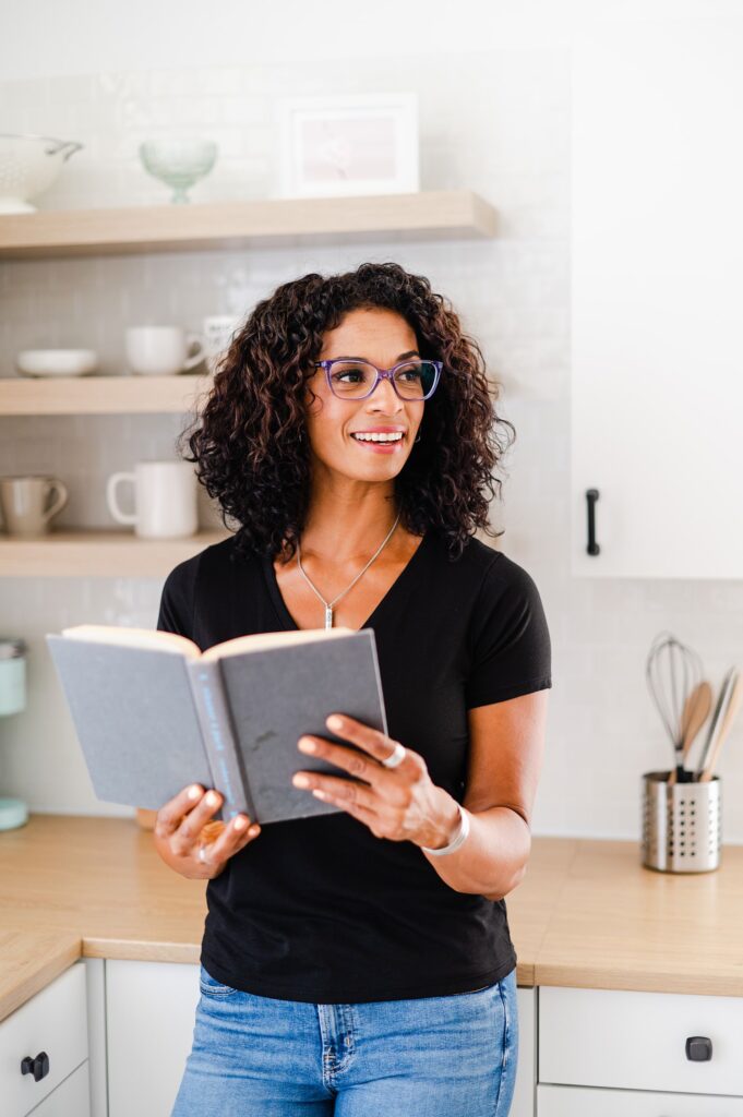 brand photo of a woman reading a book and looking off to the side