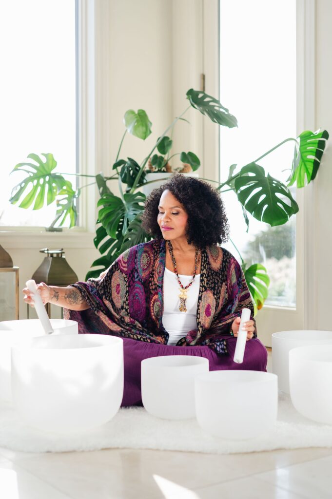 woman playing crystal sound bowls