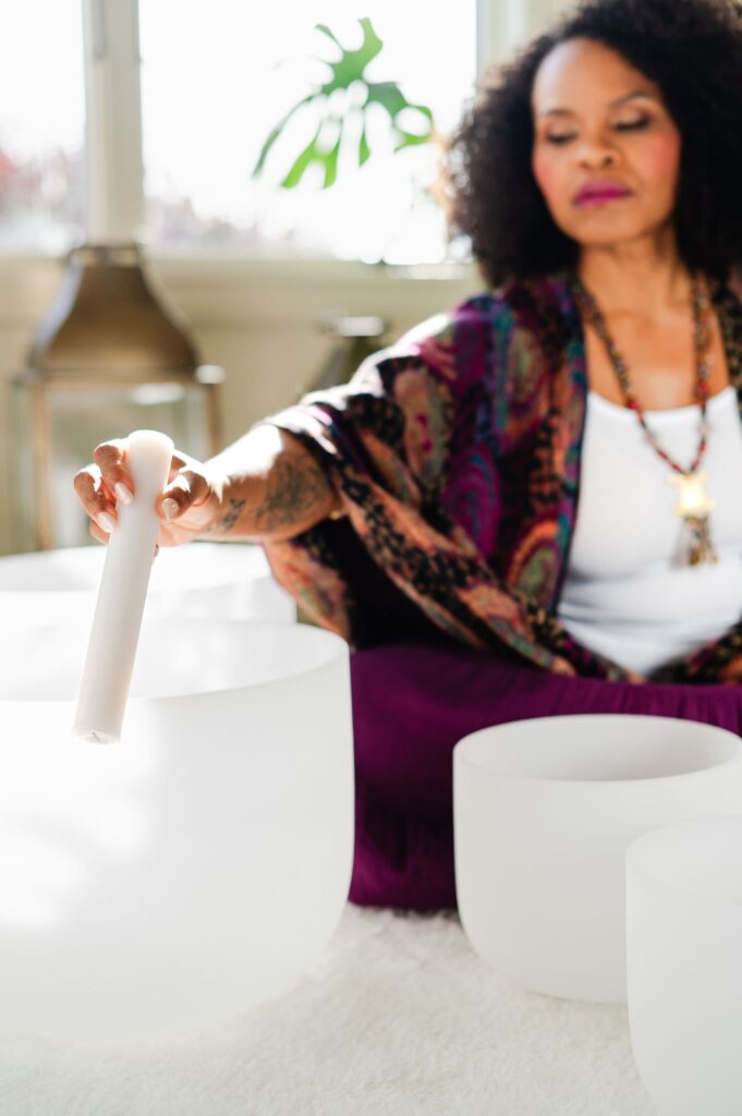 woman playing crystal sound bowls