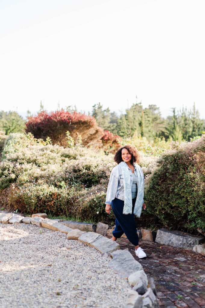 woman walking on a paved path through California greenery